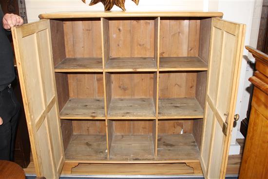 An Edwardian pine boot cupboard, with two panelled doors enclosing a fixed nine division interior, W.126cm D.48cm H.131cm